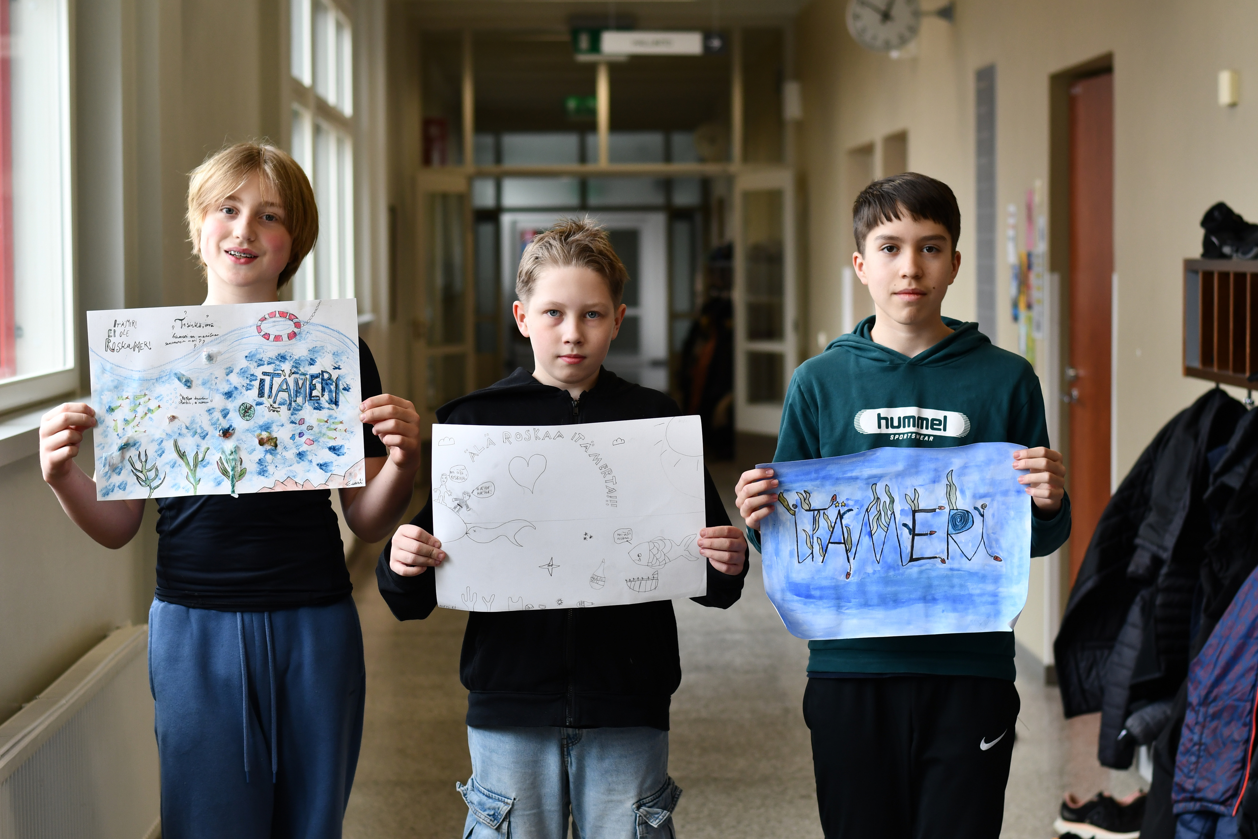 Eetu, Aarni ja Aleksi esittelevät Itämeri-aiheisia julisteitaan.