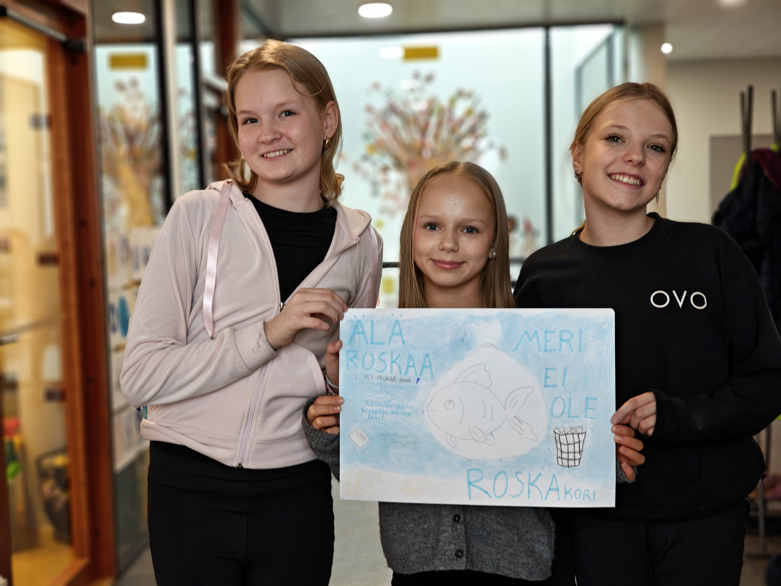 Emilia, Vilma ja Alma esittelevät julistettaan.