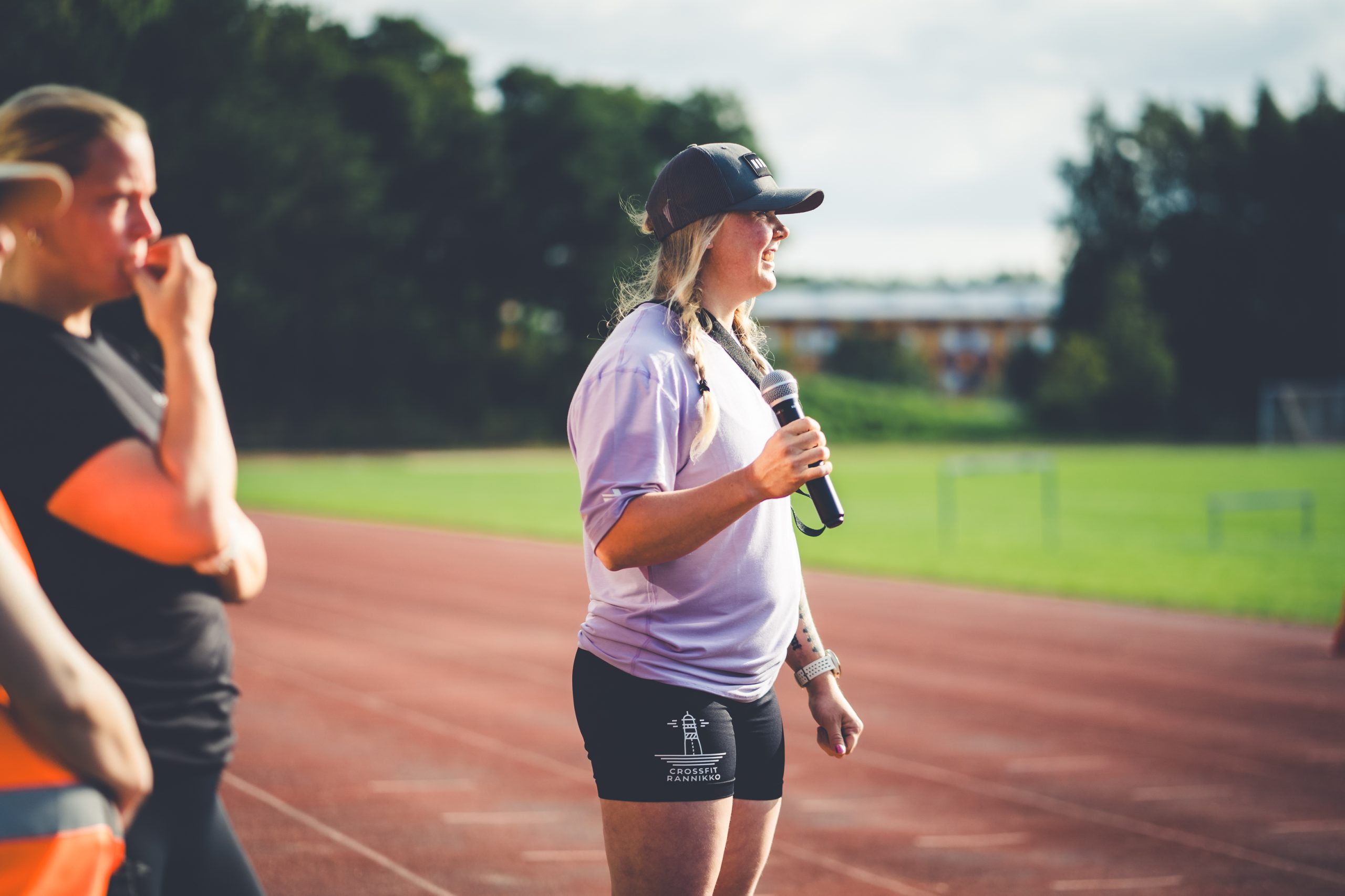 Nainen puhuu mikrofonilla yleisurheilukentällä Itämeri Run -tapahtumassa.