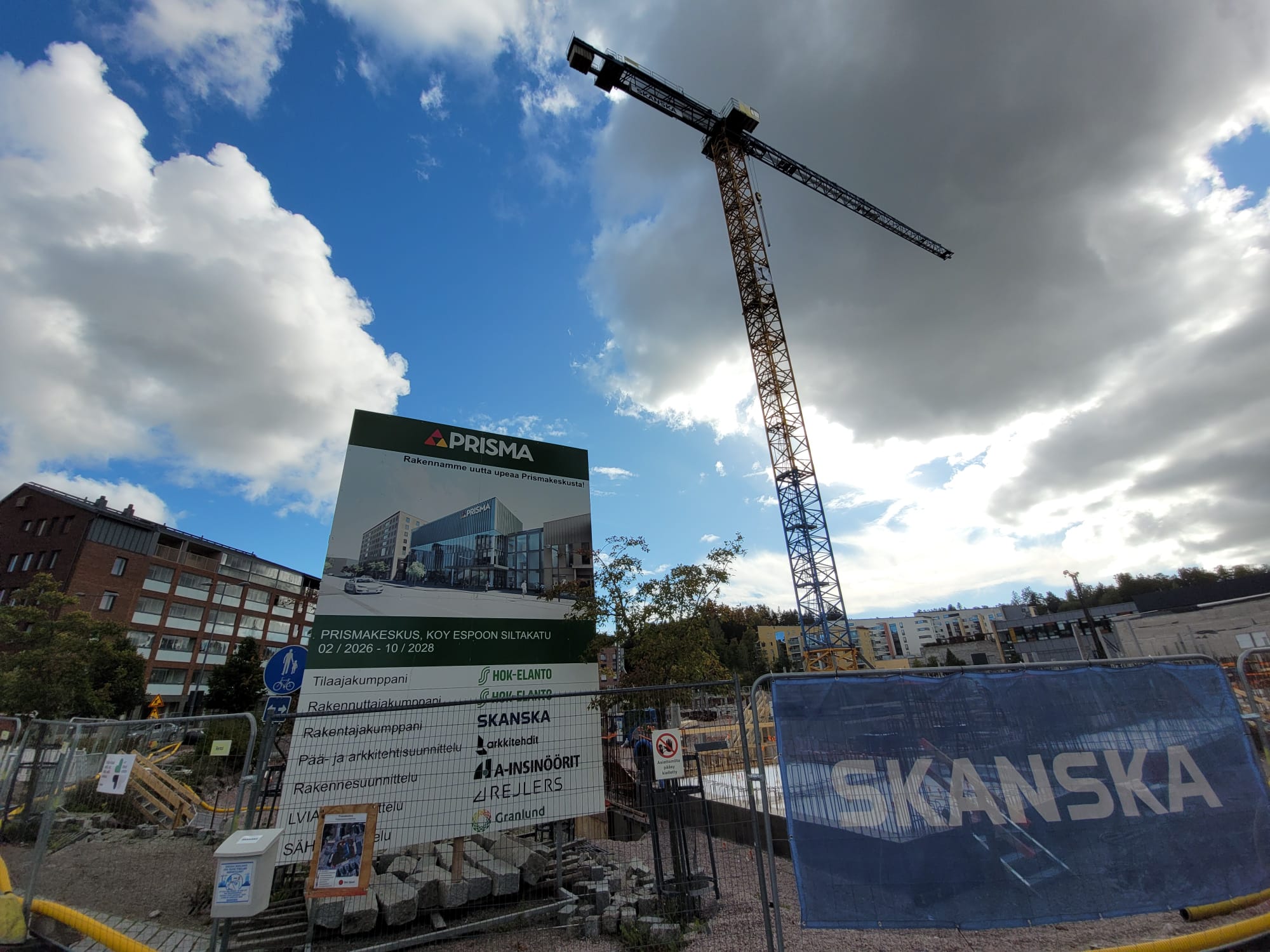 Torninosturi ja Prismakeskuksen työmaakyltti Espoon keskuksessa. Kyltissä on havainnekuva tulevasta rakennuksesta.