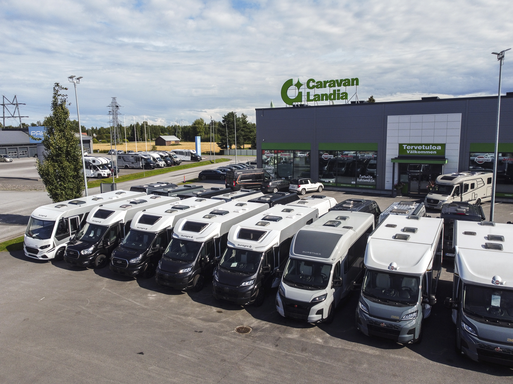 Ilmakuva Caravanlandian myymälästä ja sen eteen pysäköidyistä matkailuautoista.